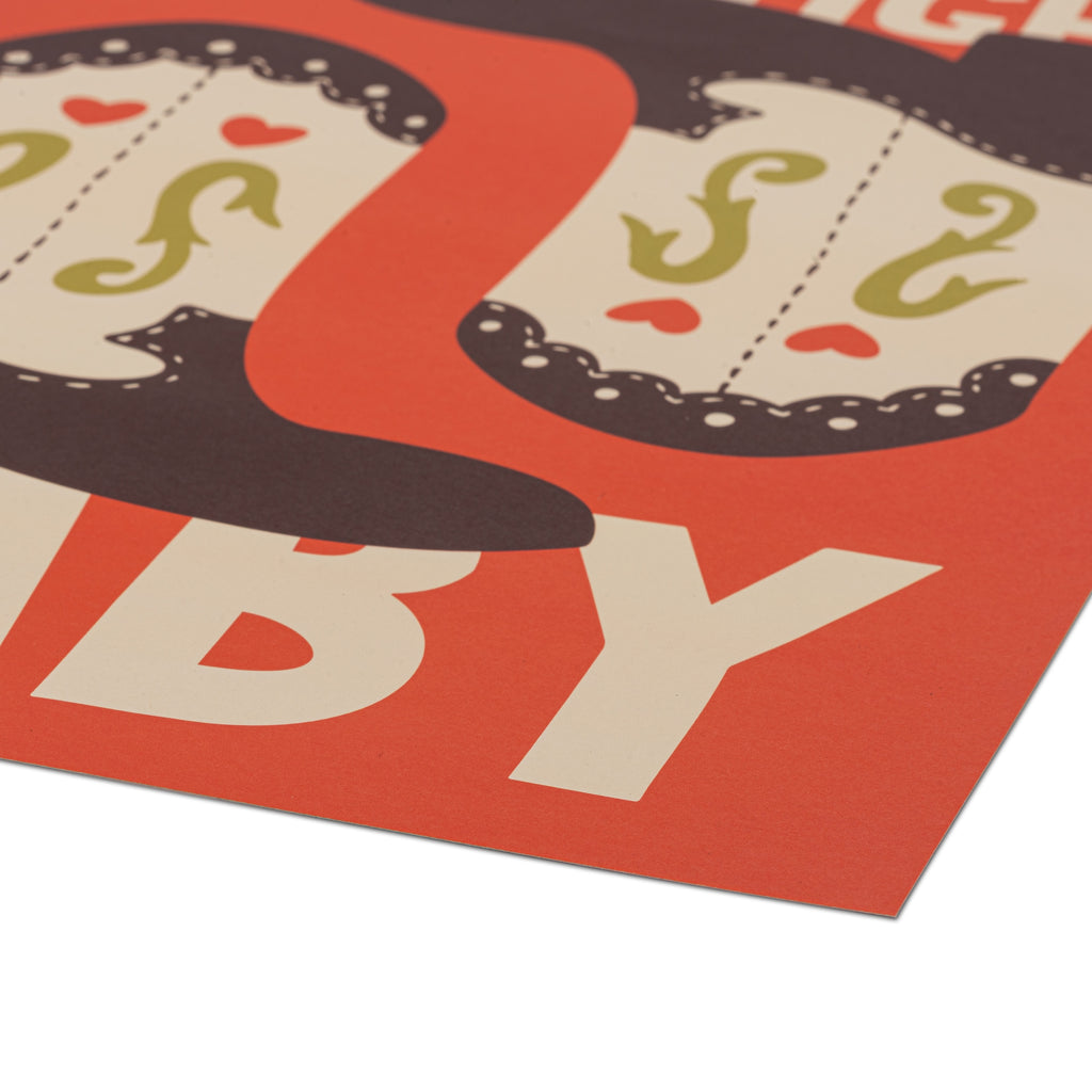 A close-up of a printed poster corner showing bold cream lettering on a bright orange-red background, with a dark brown shape at the top, photographed on a white surface.