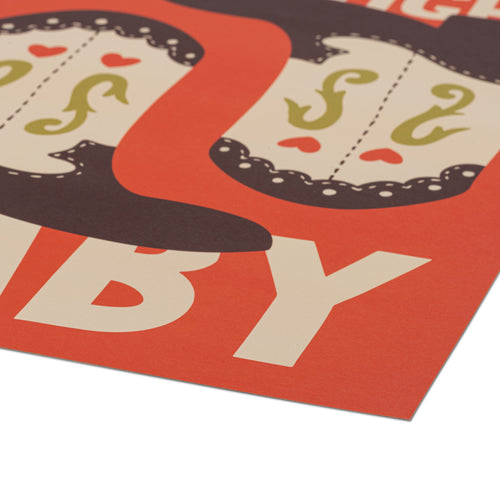 A close-up of a printed poster corner showing bold cream lettering on a bright orange-red background, with a dark brown shape at the top, photographed on a white surface.