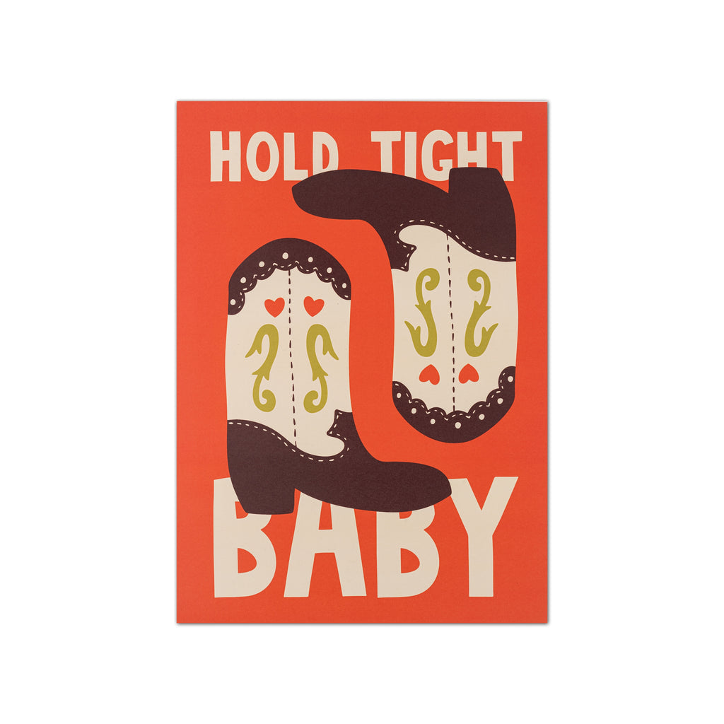 A square graphic print with the words 'HOLD TIGHT BABY' in large cream letters on a burnt orange background, with two stylized cowboy boots in dark brown and cream between the words.