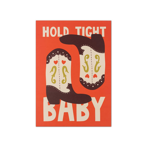A square graphic print with the words 'HOLD TIGHT BABY' in large cream letters on a burnt orange background, with two stylized cowboy boots in dark brown and cream between the words.